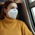 Frau mit FFP2-Maske in einem Zug