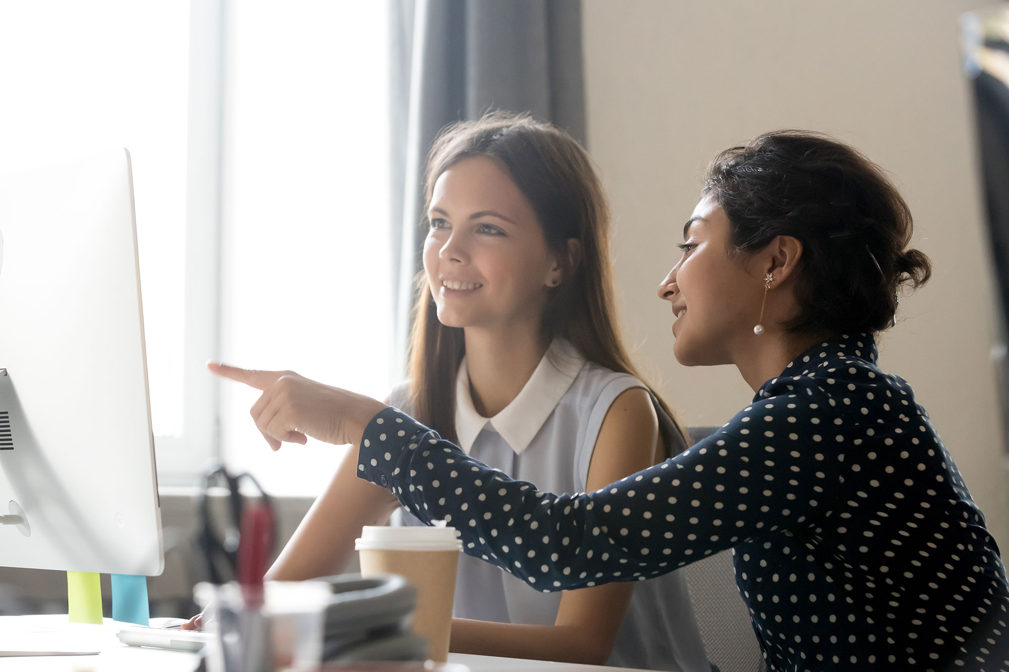 Junge Frauen sitzen vor einem PC