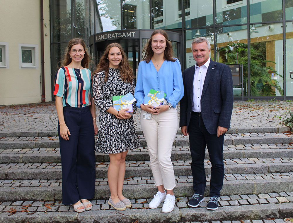 Bild: Landrat Peter Dreier und Ausbildungsleiterin Theresa Schmailzl (l.) gratulieren Sabrina Krausnecker und Laura Lang zur bestandenen Abschlussprüfung zur Verwaltungsfachangestellten.