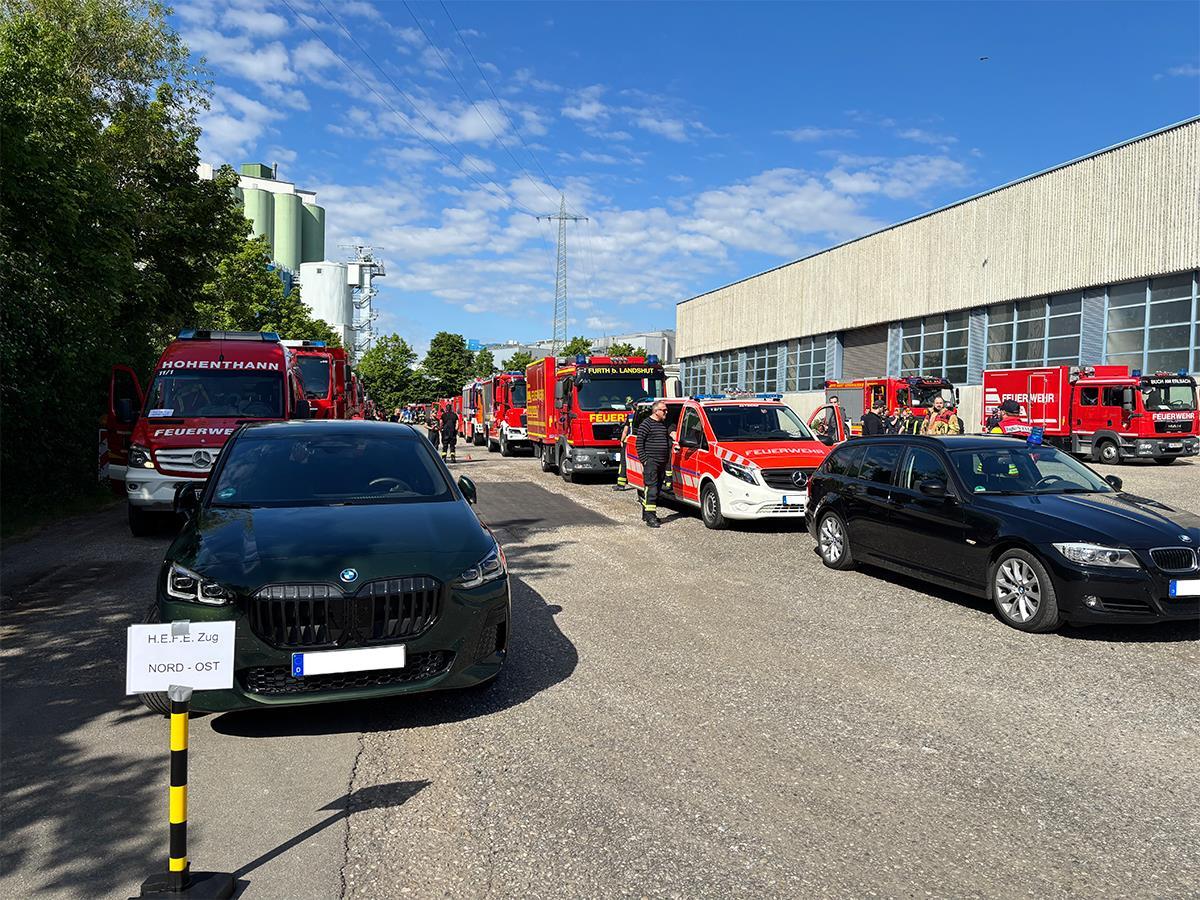 Mehrere Autos und Einsatzwägen vor einer Firmenhalle