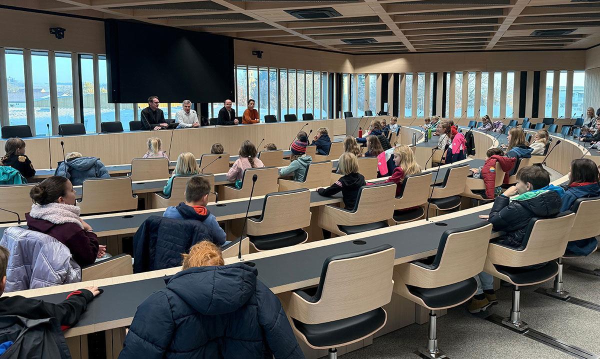 Personen auf Stühlen im Sitzungssaal